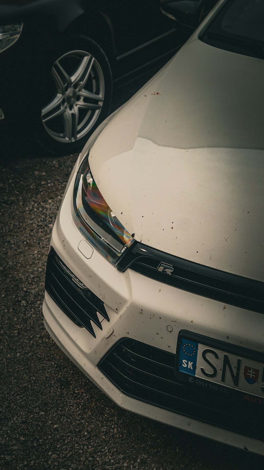 a-close-up-of-a-white-car-parked-in-a-parking-lot-kk-zjcqzl9u